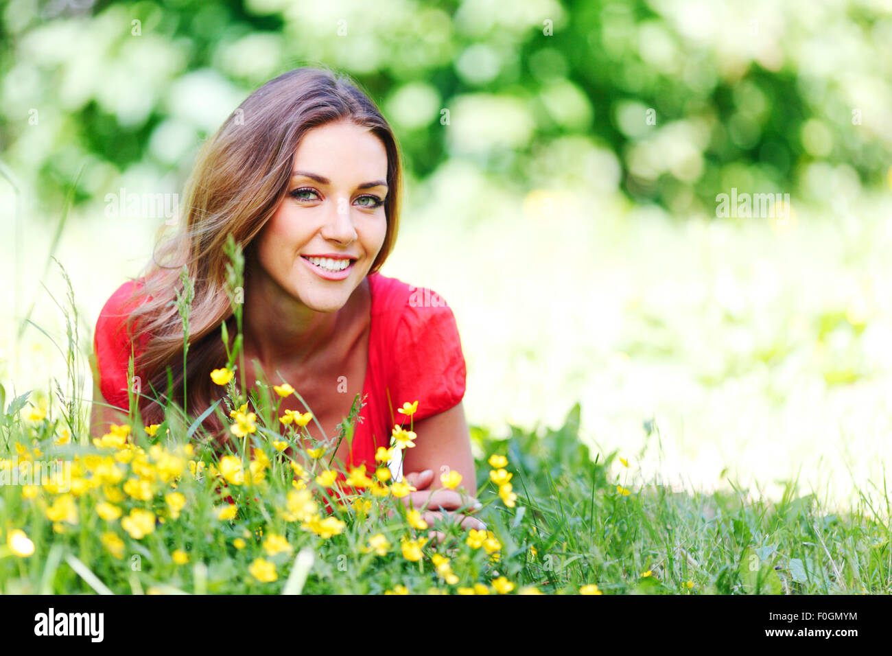 young woman in red dress lying on grass Stock Photo - Alamy