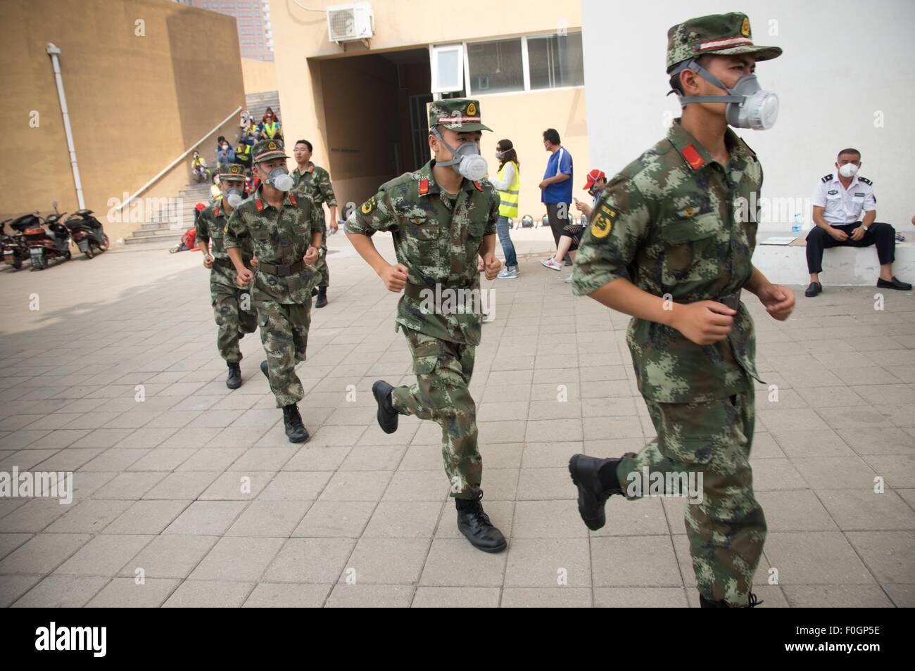 China. 15th Aug, 2015. Soldiers seen wearing gas masks in the exclusion zone as the authority had confirmed the existent of toxic gas in the area. The death toll has risen to 104. Local authority starts to evacuate local residents from the temporary camp located at a local school near the blast zone as they extend the exclusion zone to 3 km from where the explosion happened as poison air which could cause cancer is being detected. © Geovien So/Pacific Press/Alamy Live News Stock Photo