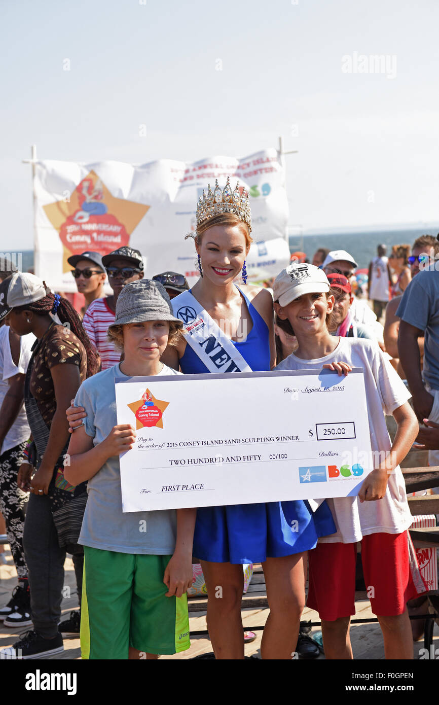 Brooklyn, United States. 15th Aug, 2015. Miss USA, New York presents check to winners in youth category. Contestants and teams participated in the 25th annual Coney Island Sand Sculpting contest. © Andy Katz/Pacific Press/Alamy Live News Stock Photo