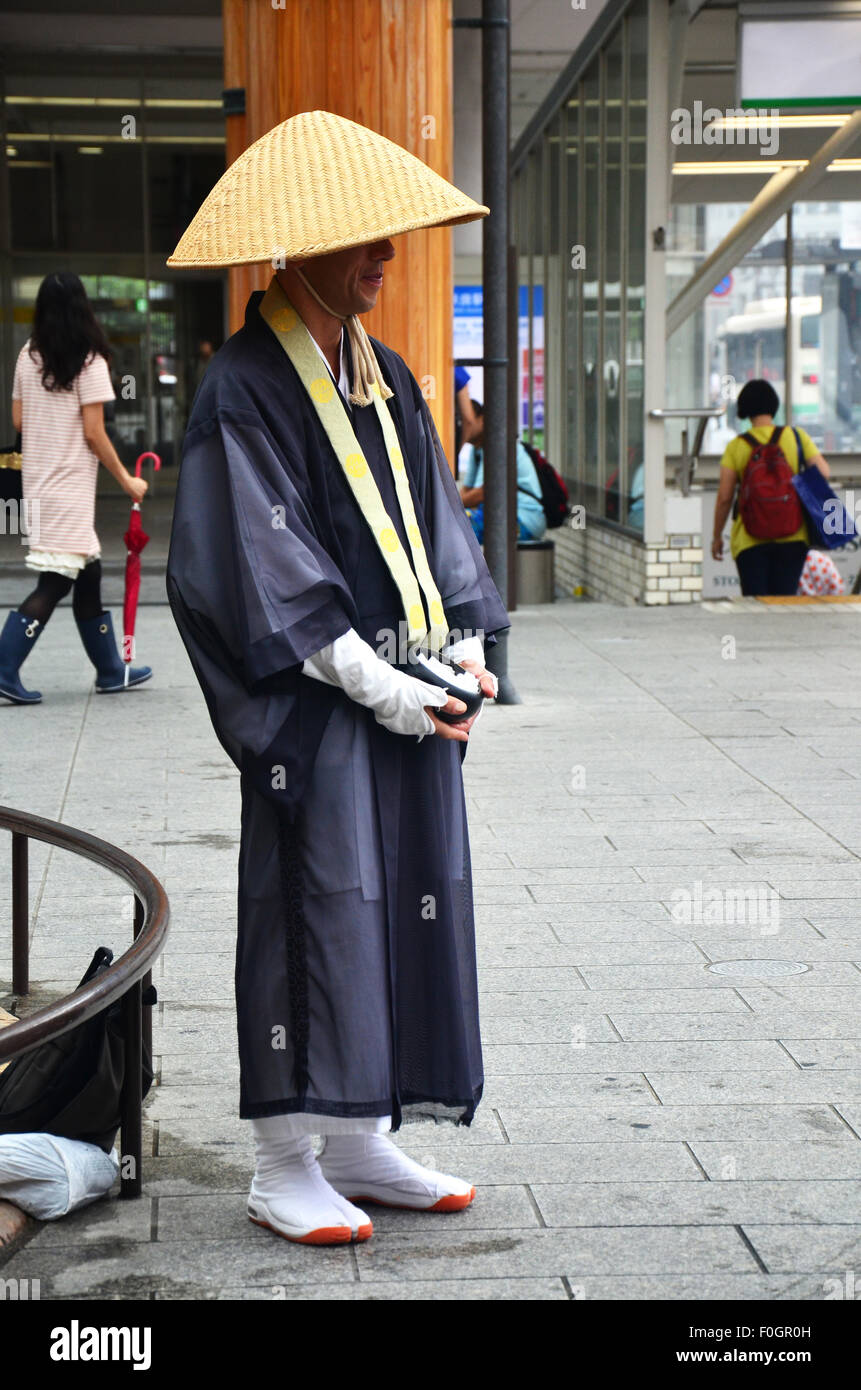 Japanese monk standing at front of a small fountain near the kintetsu Nara station for receive donation from people on July 7, 2 Stock Photo