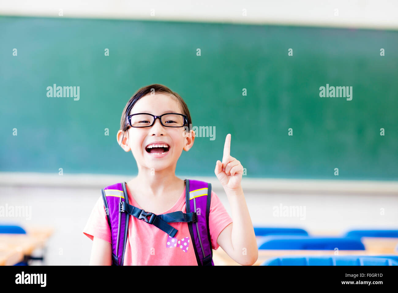 happy little girl with idea gesture in the classroom Stock Photo