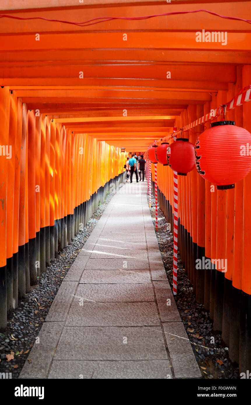 People travel and walking path inside through a tunnel of torii gates ...