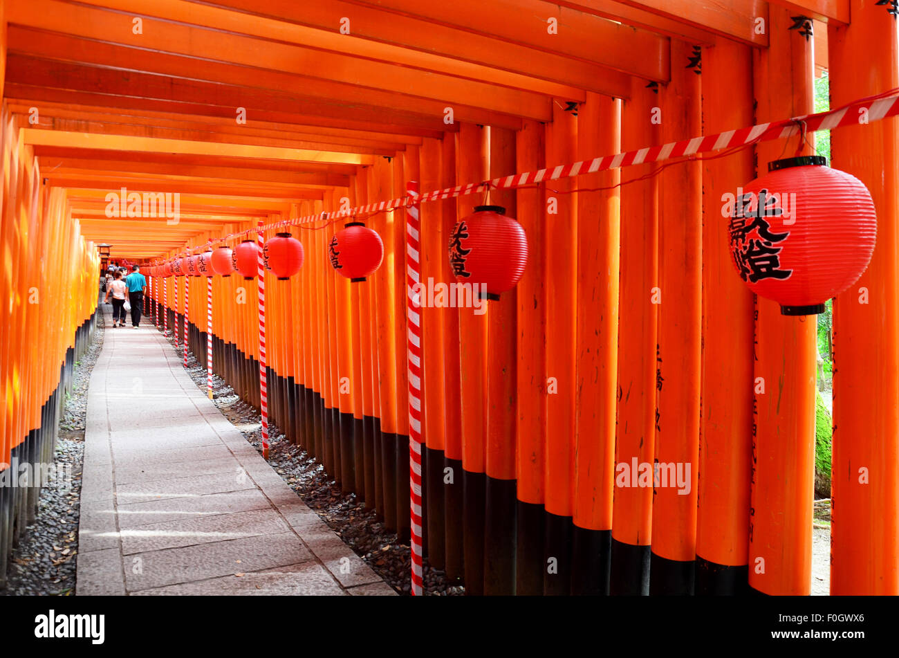People travel and walking path inside through a tunnel of torii gates ...