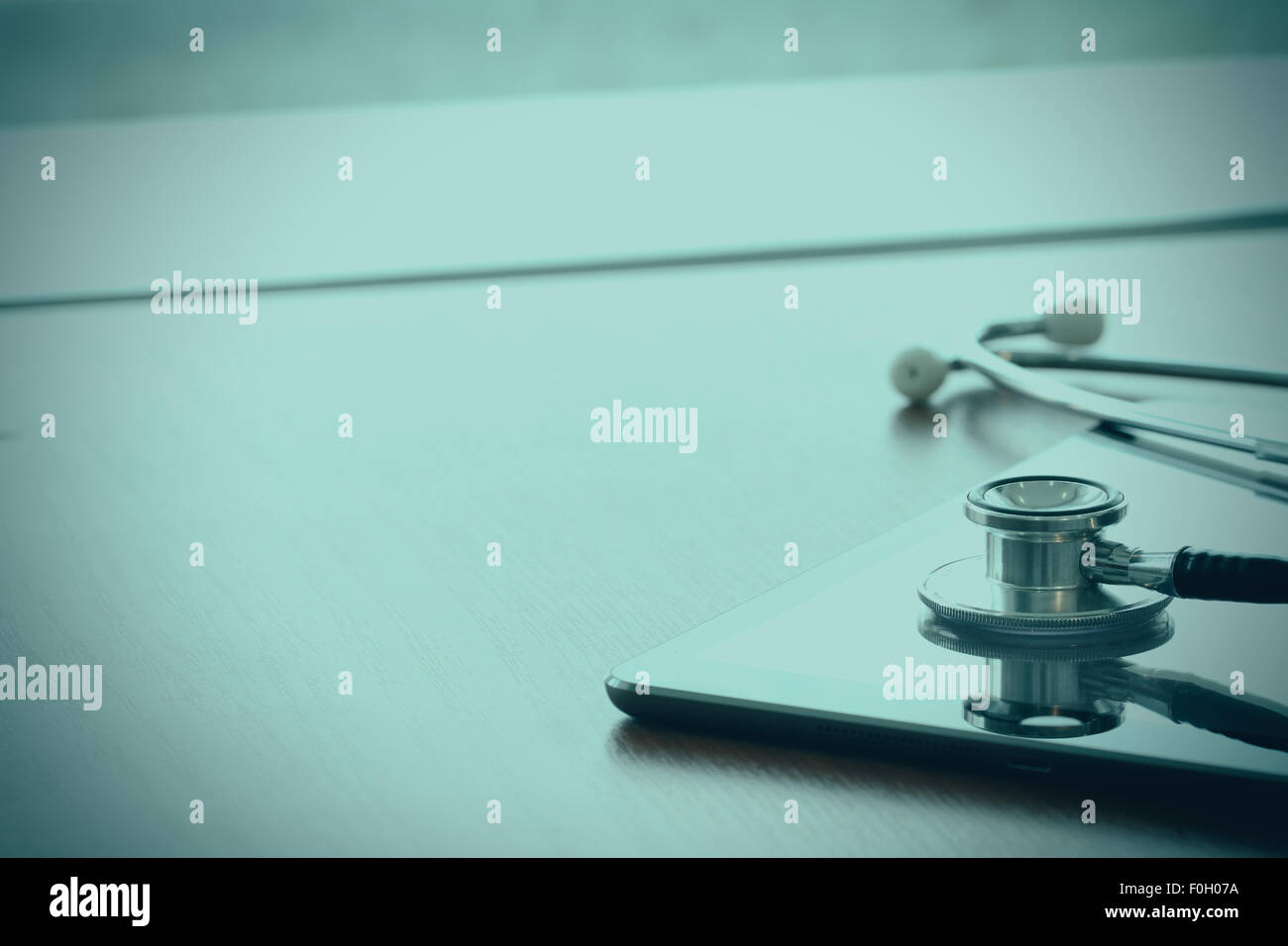 Studio macro of a stethoscope and digital tablet abstract on wood table ...