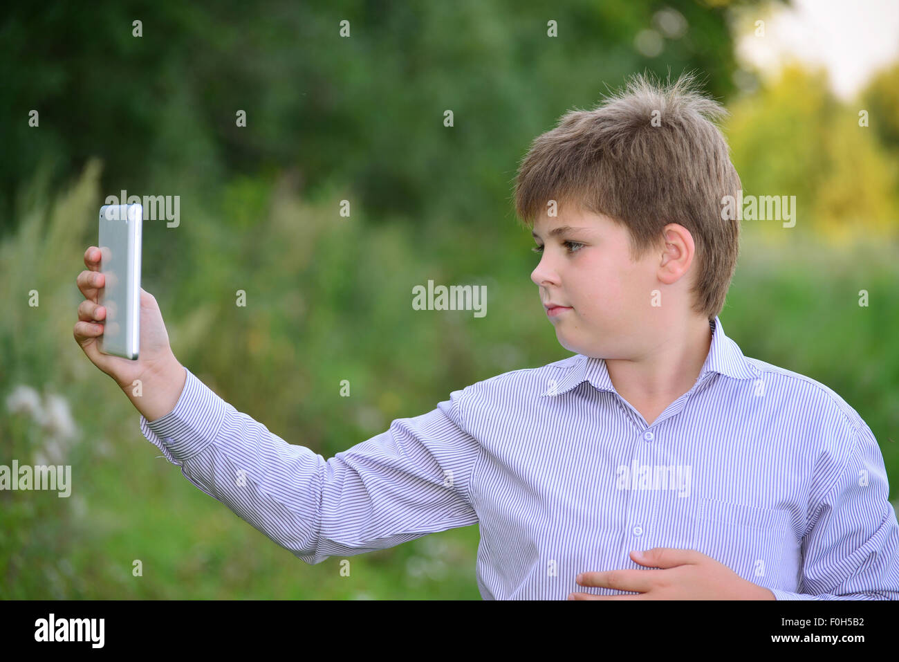 Teen boy with  tablet computer at nature Stock Photo