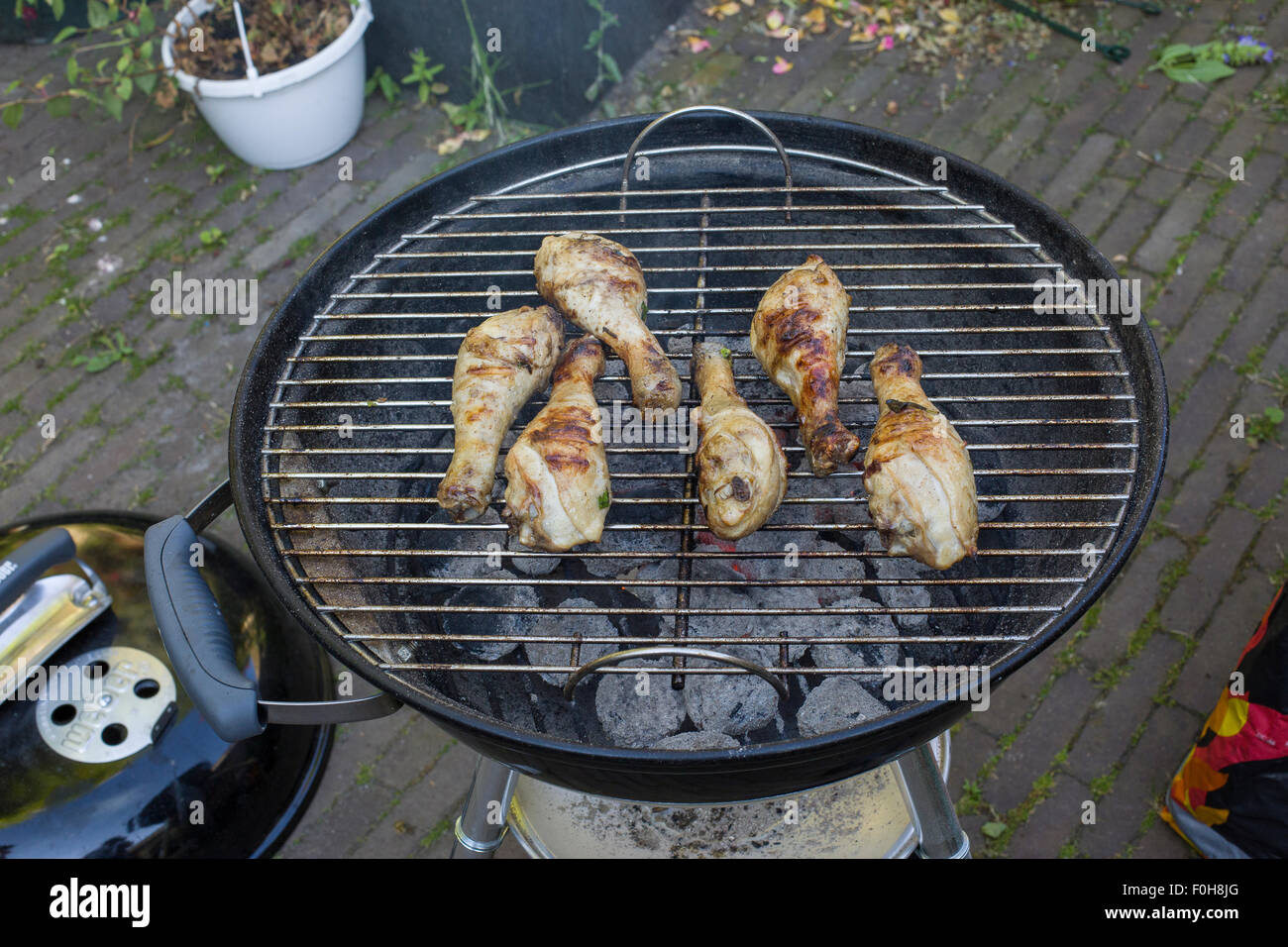 Grilling chicken legs on the barbecue in the garden Stock Photo Alamy
