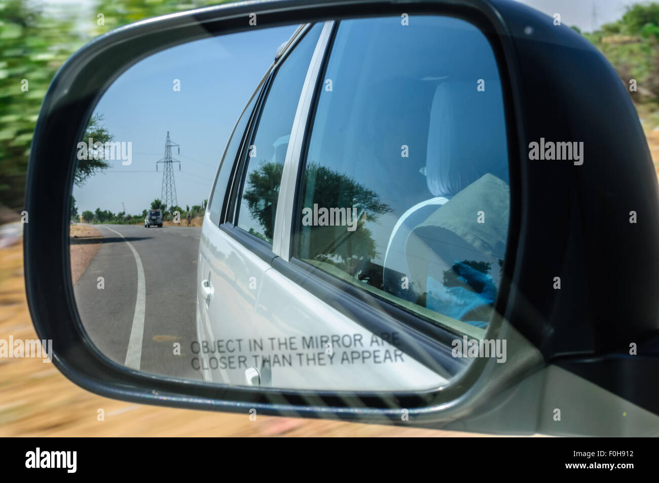 View through rearview mirror of a car moving on highway through desert