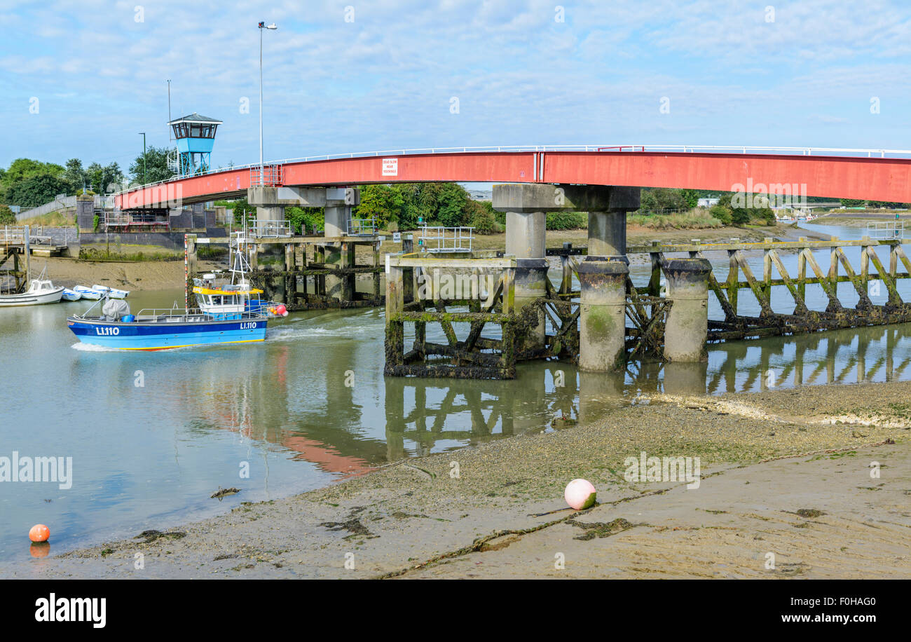 Boat going under the retractable footbridge across the River Arun at low tide in Littlehampton, West Sussex, England, UK. Stock Photo