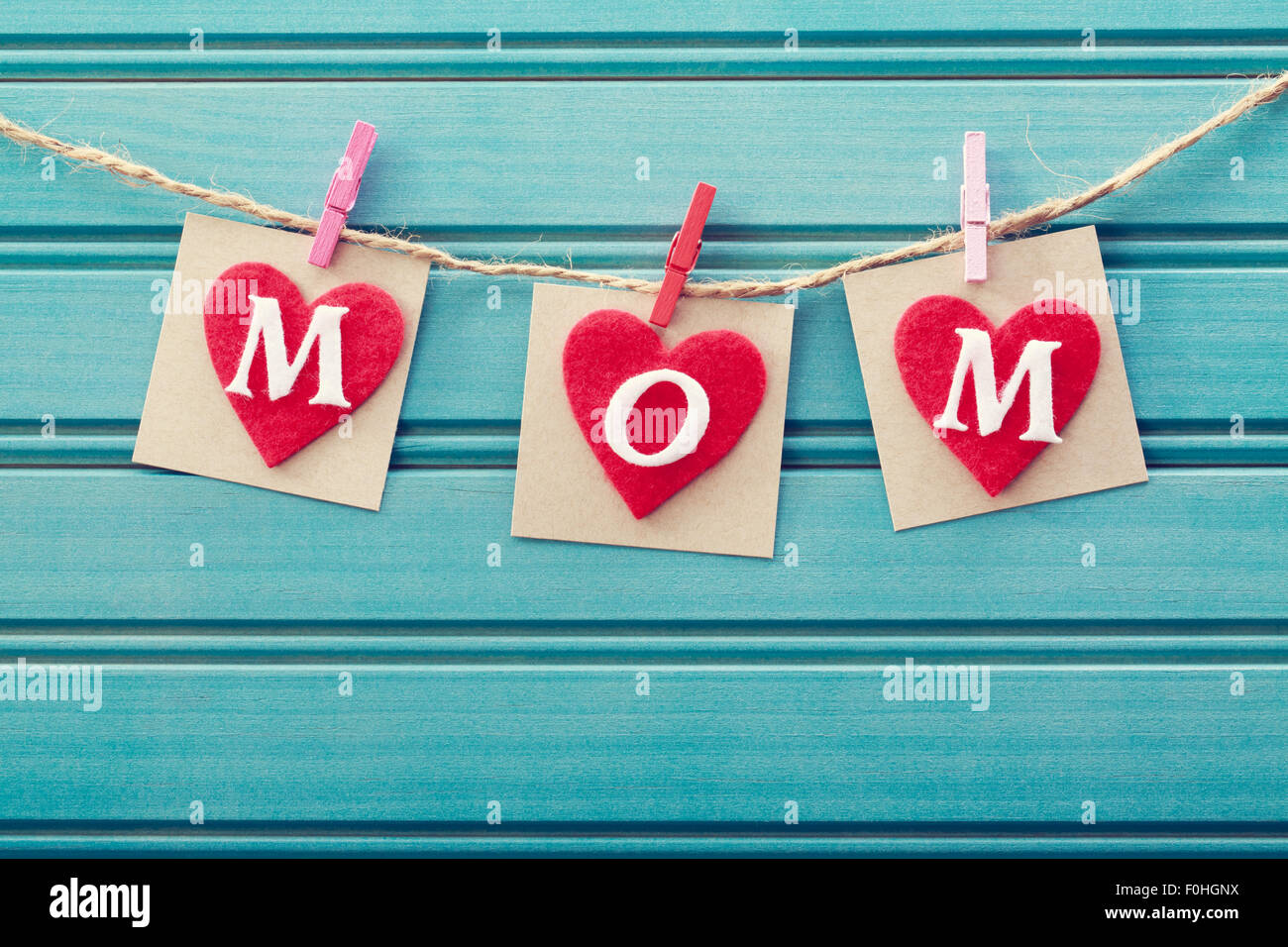 Mothers day message on felt hearts over blue wooden board Stock Photo