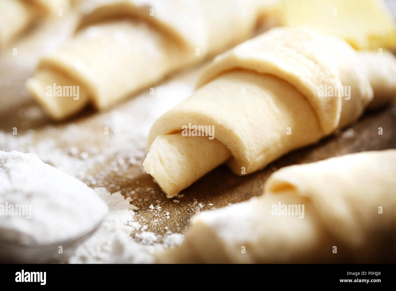 Croissants dough freshly prepared for baking with flour on wooden board Stock Photo