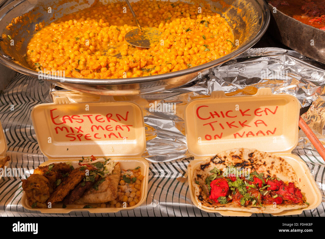 Close up of Indian or Asian fast food takeaway dishes on sale at ...