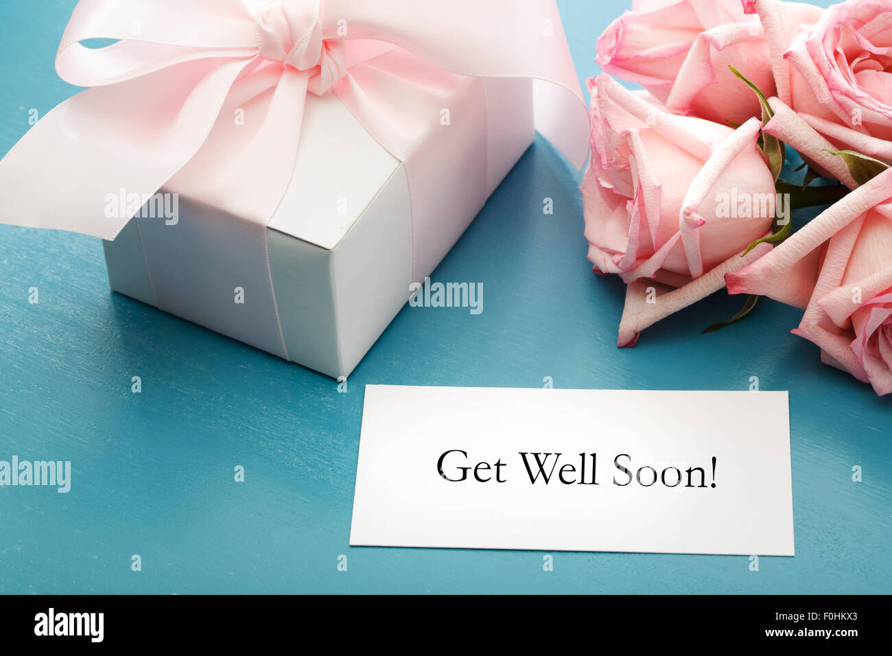 Get Well Soon card with gift box and pink roses Stock Photo