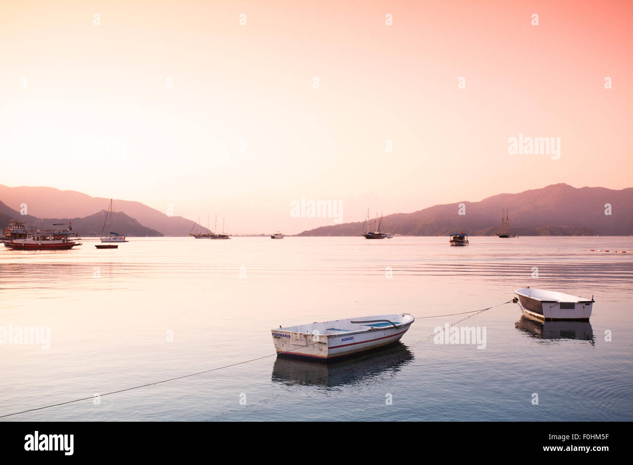 two small boats tied with rope at Aegean sea bay Stock Photo