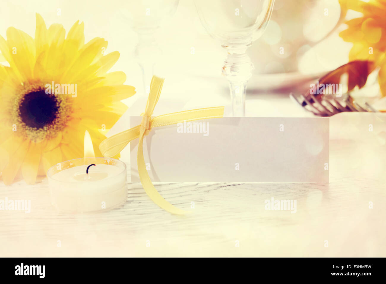 Decorated table setting and blank message card with yellow gerberas Stock Photo