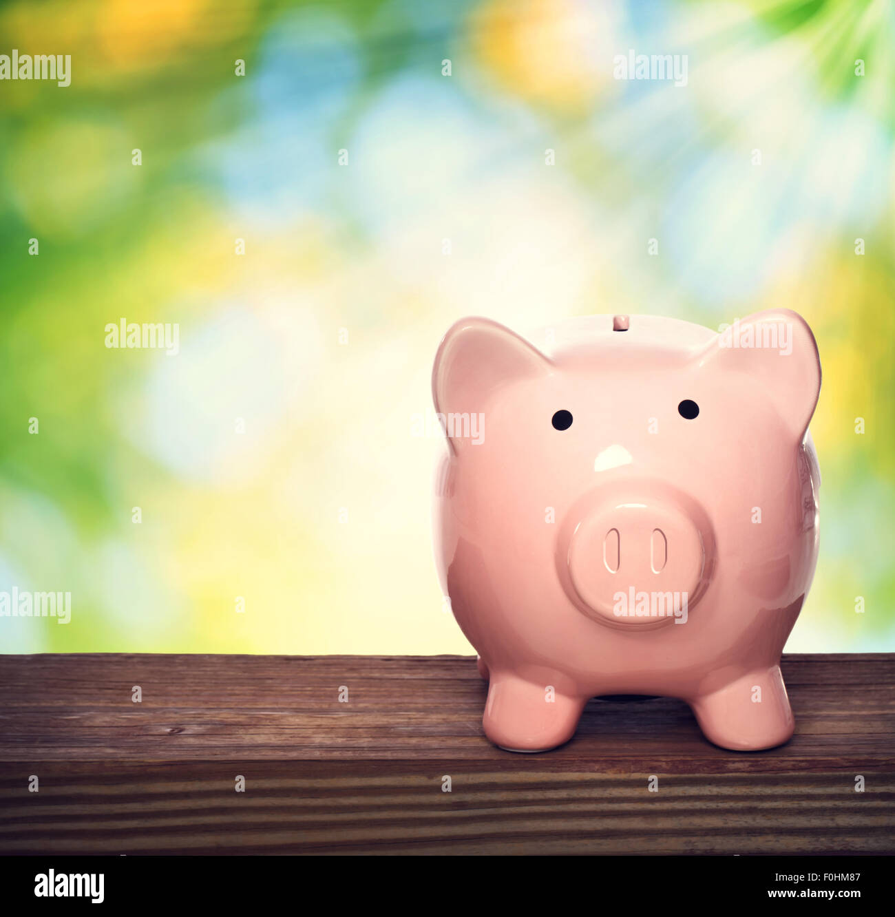Pink piggy bank over shiny leaves background Stock Photo - Alamy