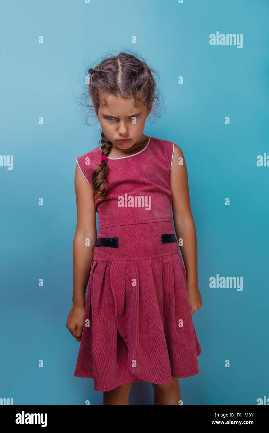 Girl European appearance decade  angry frowns on blue background Stock Photo