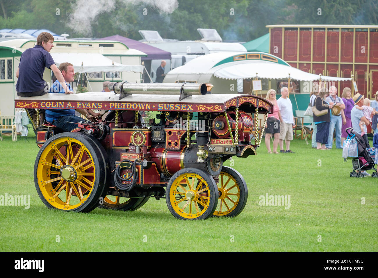 small steam powered traction engine being driven at the weald and