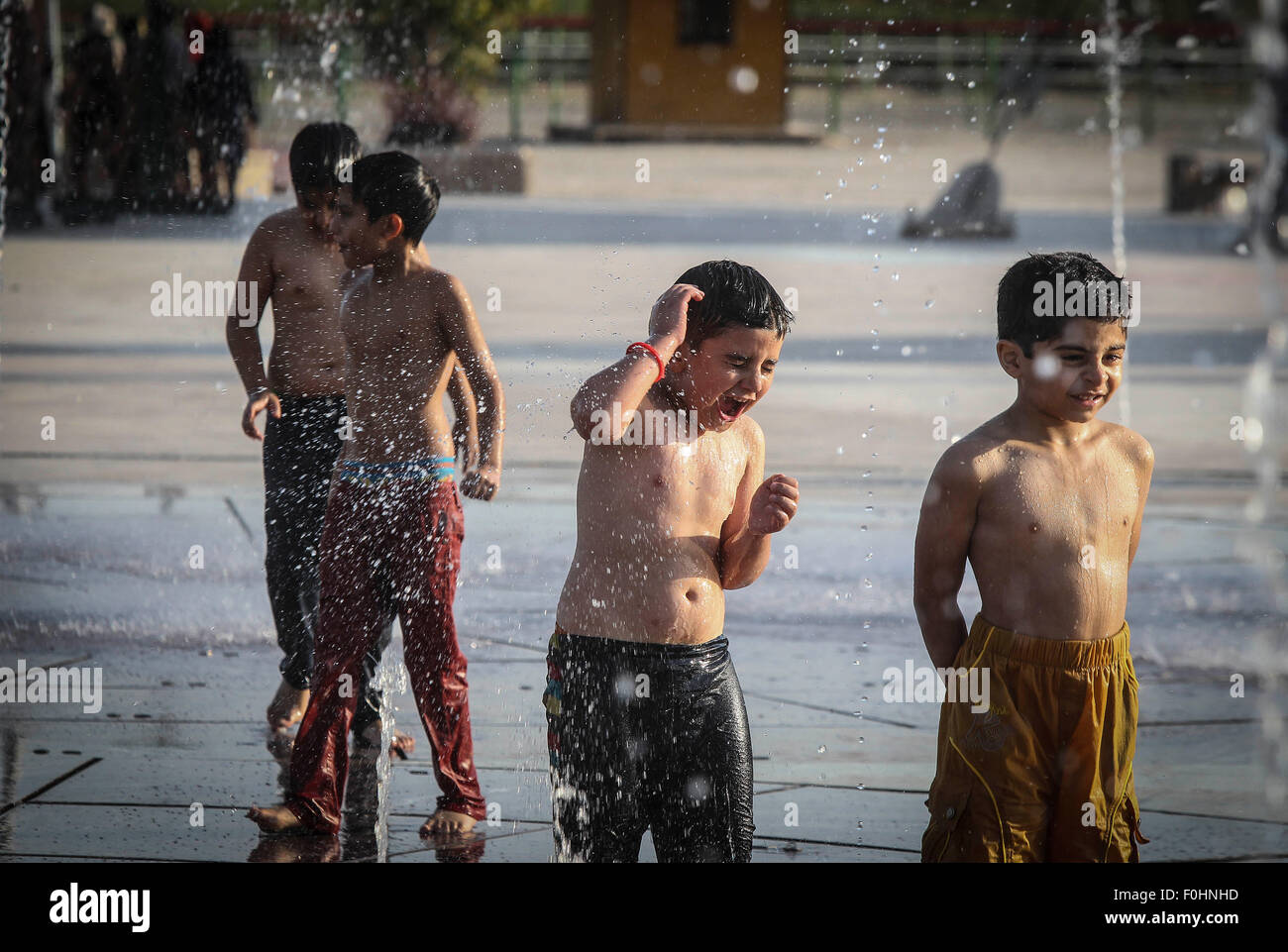 Tehran, Iran. 16th Aug, 2015. Iranian children play with water at a park in Tehran, Iran, on Aug. 16, 2015. A heatwave with the temperature of over 38 degrees Celsius swept the city. Credit:  Ahmad Halabisaz/Xinhua/Alamy Live News Stock Photo