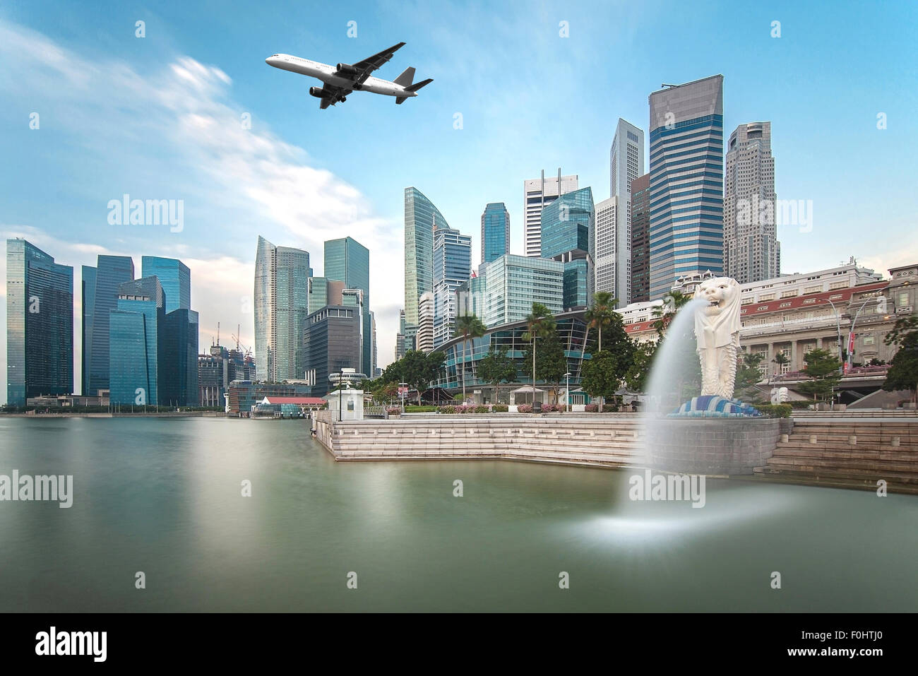 Travel, Transportation concept - Airplane flying over Singapore city in morning time Stock Photo