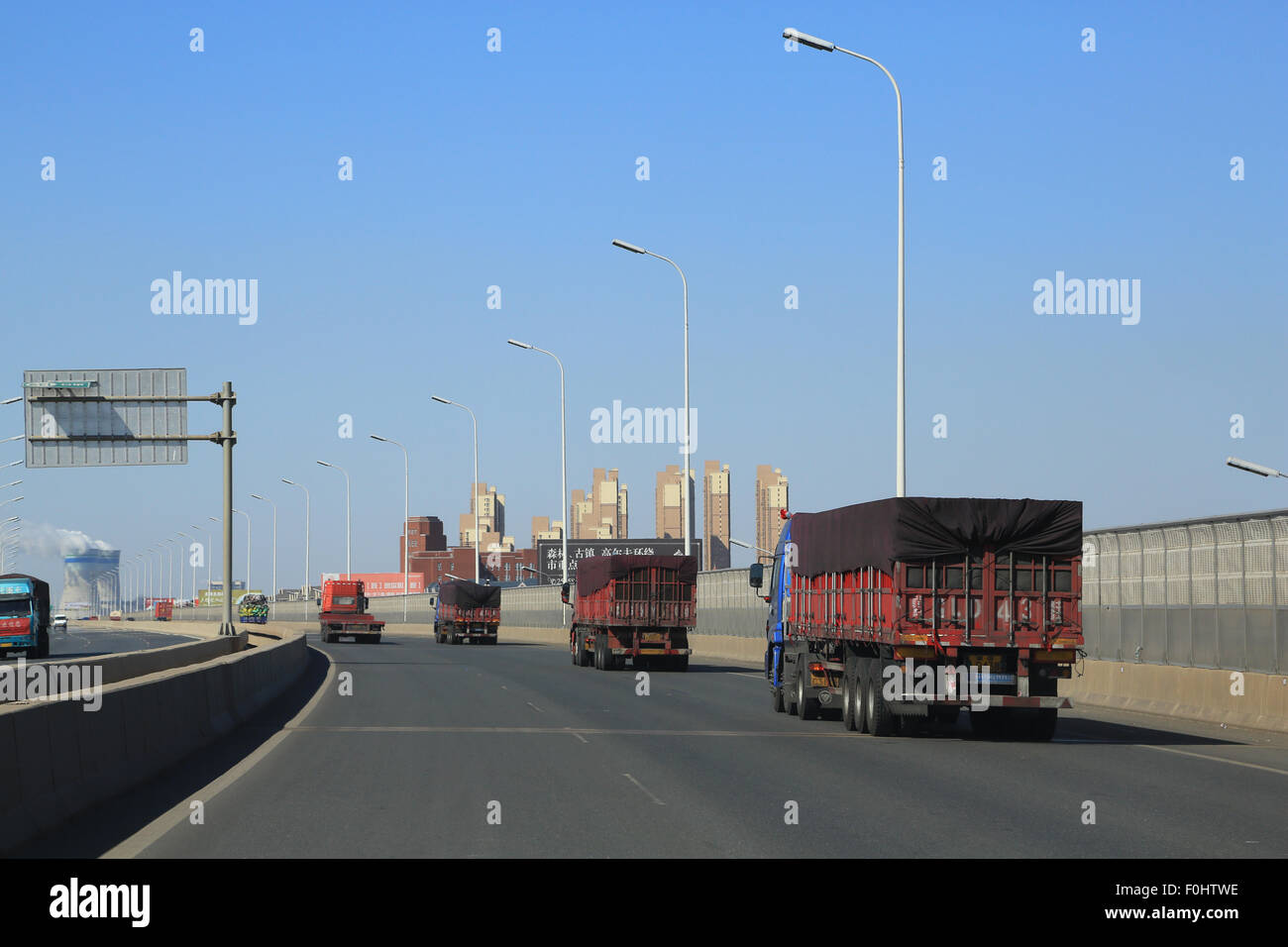 Container truck traffic on freeway leaving Tianjin port heading toward Beijing. Stock Photo