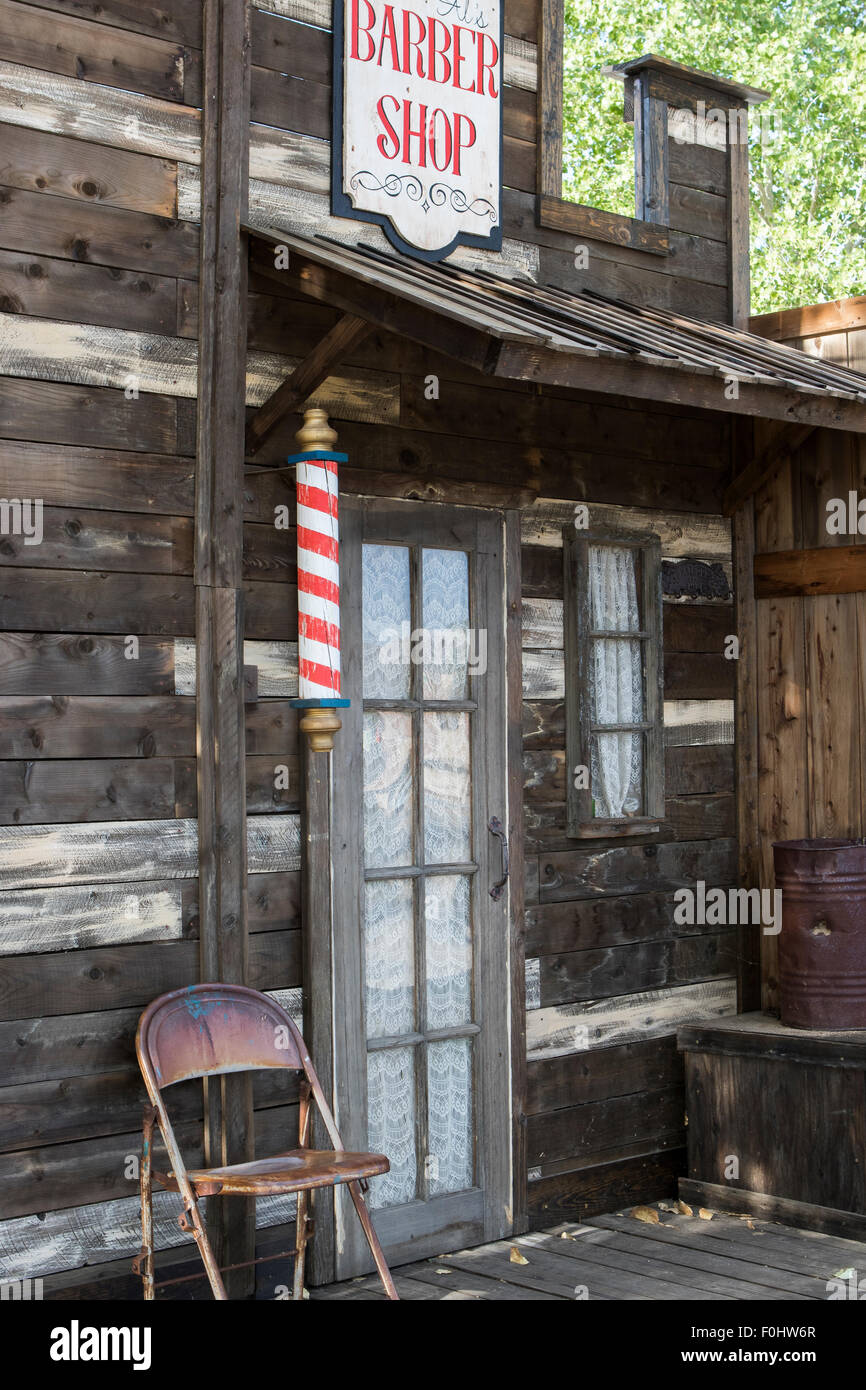 Wild west style Barbers shop exterior facade with red sign and red and white barbers pole in Joshua tree California Stock Photo