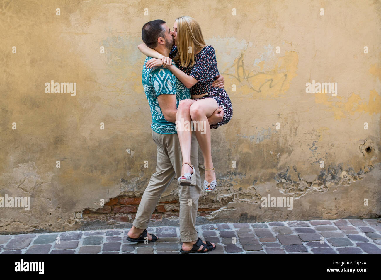 Happy young couple in love having fun against the wall of the house. Stock Photo