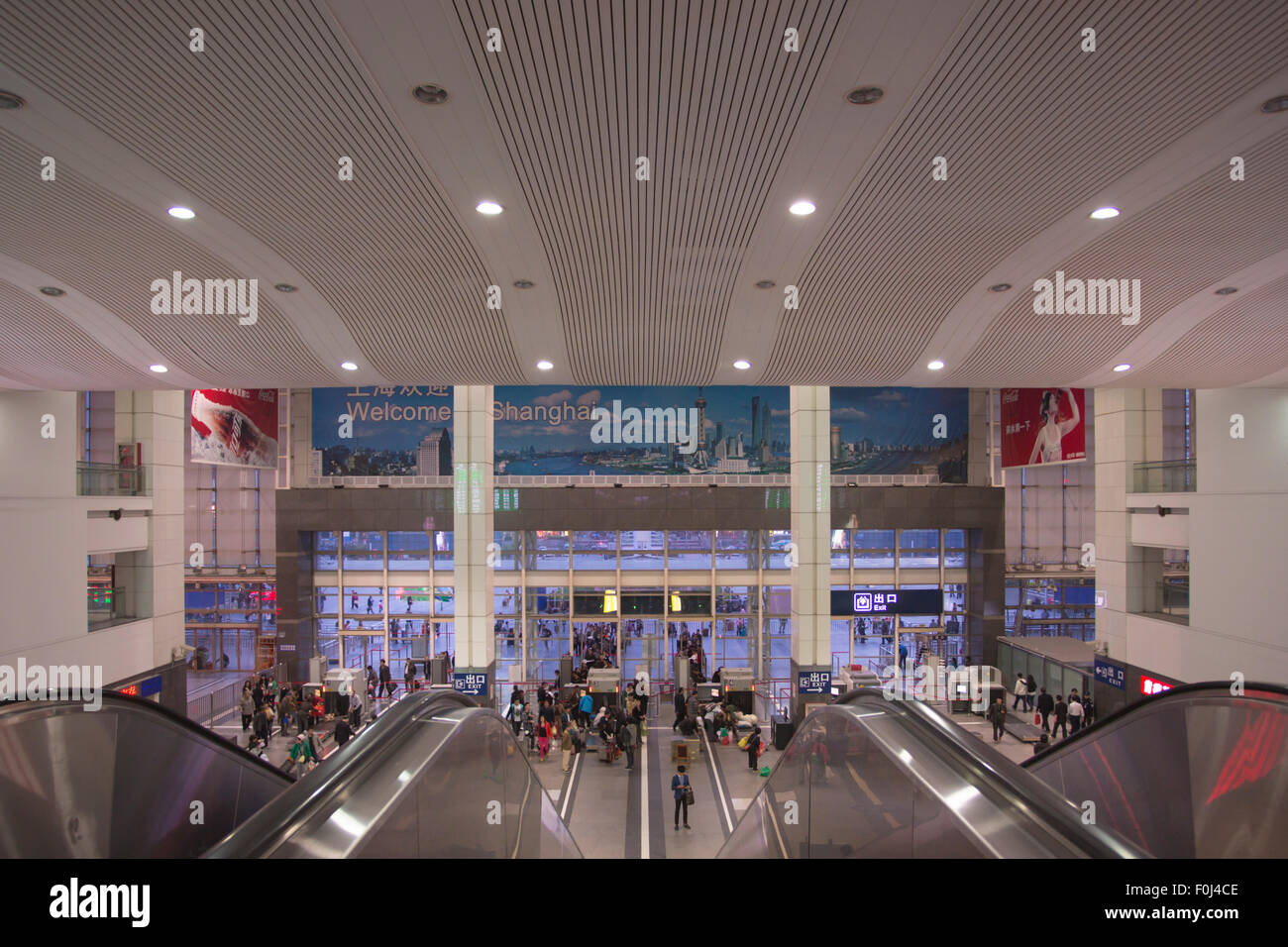 Interior of the main Shanghai train station with unidentified travelers late afternoon. Stock Photo