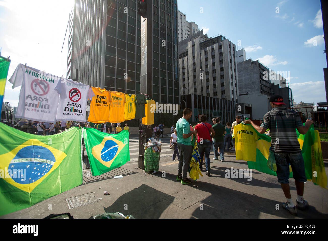Sao Paulo, Brazil. 16th Aug, 2015. Venders sale Brazil national flag and T-shirt with slogan 'Dilma out' on the Paulista Avenue during an anti-government demonstration in Sao Paulo, Brazil, Aug. 16, 2015. A demonstration took place on the Paulista Avenue in downtown Sao Paulo on Sunday with thousands of protesters marching with slogans on flags and cardboards. Support for Brazilian President Dilma Rousseff has fallen to eight percent in a recent poll as she was accused of failing to curb corruption and the slump of economy. Credit:  Xu Zijian/Xinhua/Alamy Live News Stock Photo