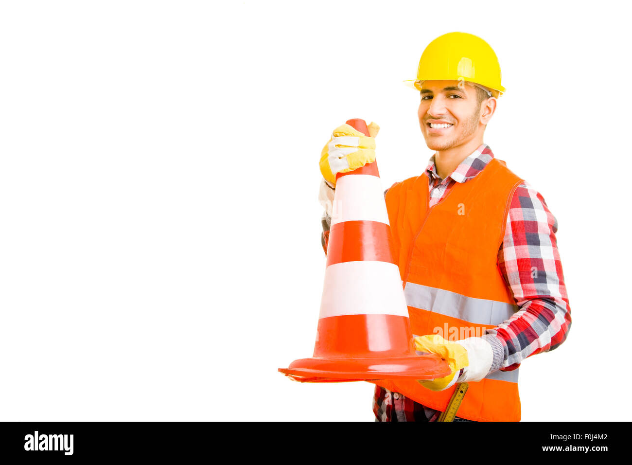 Happy construction worker carrying a traffic cone Stock Photo