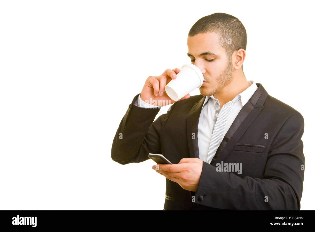 Business man drinking while looking at his cell phone Stock Photo