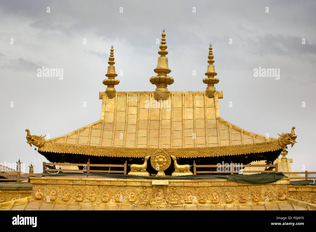 Cloudy sky and detail of the golden roof from the Jokhang Temple in Lhasa, Tibet. Stock Photo