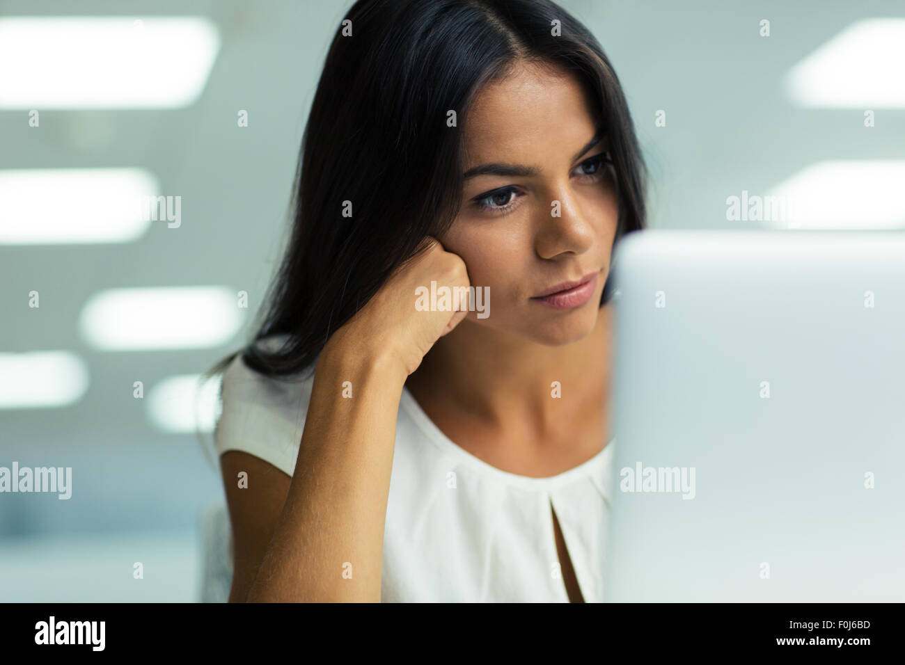 Portrait of a young beautiful businesswoman working on laptop in office Stock Photo