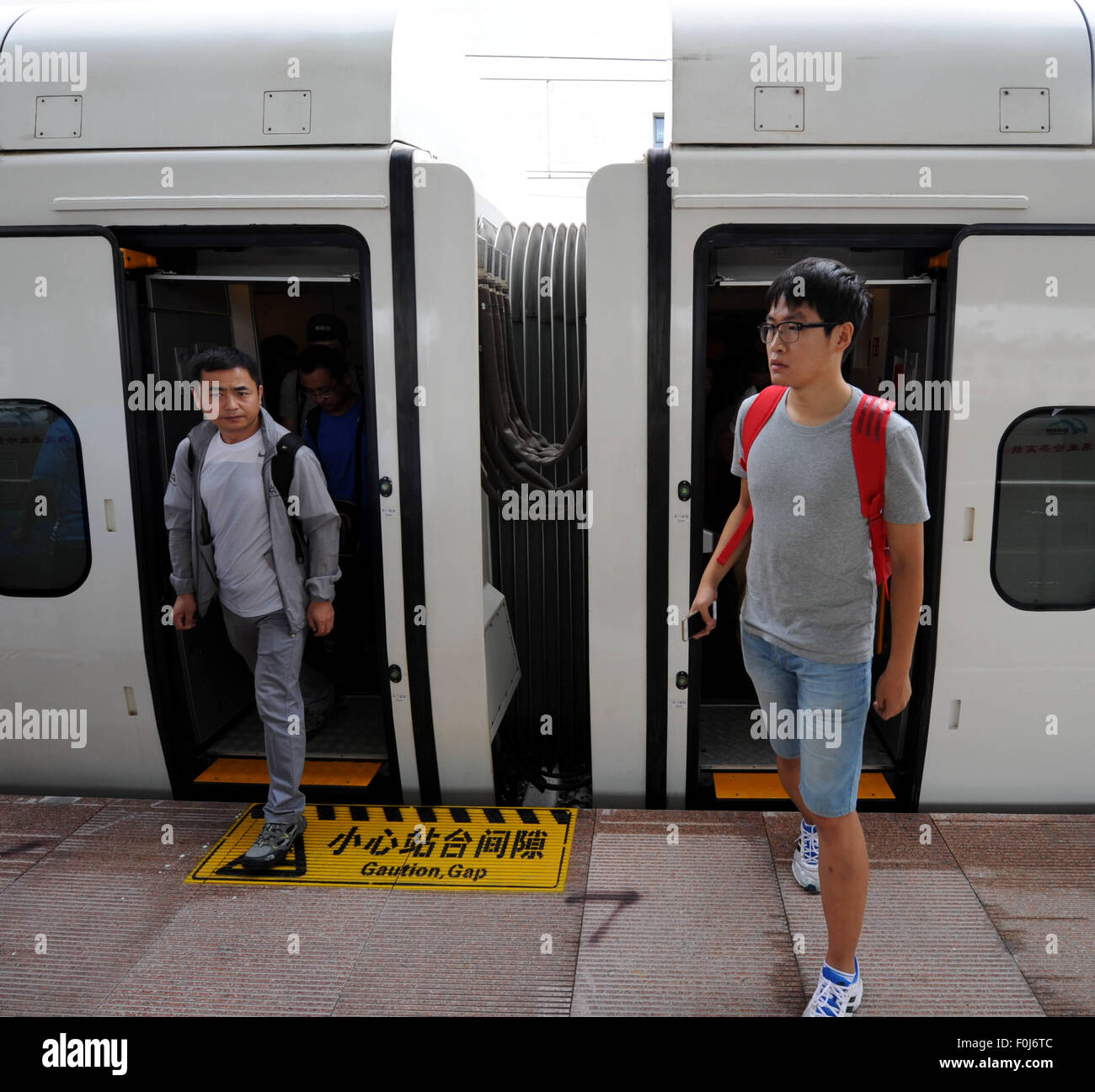 (150817) -- HARBIN, Aug. 17, 2015 (Xinhua) -- Passengers get off the train at the Daqing West Railway Station in Daqing, northeast China's Heilongjiang Province, Aug. 17, 2015. China's northernmost high-speed railway between two cities of Harbin and Qiqihar in Heilongjiang started operation on Monday. With a designated speed of 250 kilometers per hour and eight stops, the trip from Harbin to Qiqihar was reduced from three hours to 85 minutes. The trains have been modified to adapt to temperatures as low as minus 40 degrees Celsius and resist adverse weather, such as strong winds, heavy rain, s Stock Photo