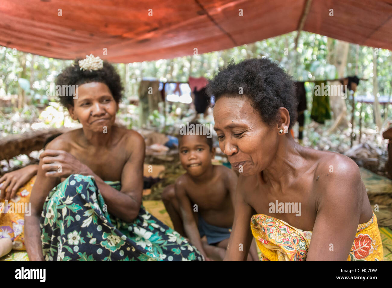 Women and children of the Orang Asil tribe sitting under tarpaulins in the jungle, native, indigenous people Stock Photo