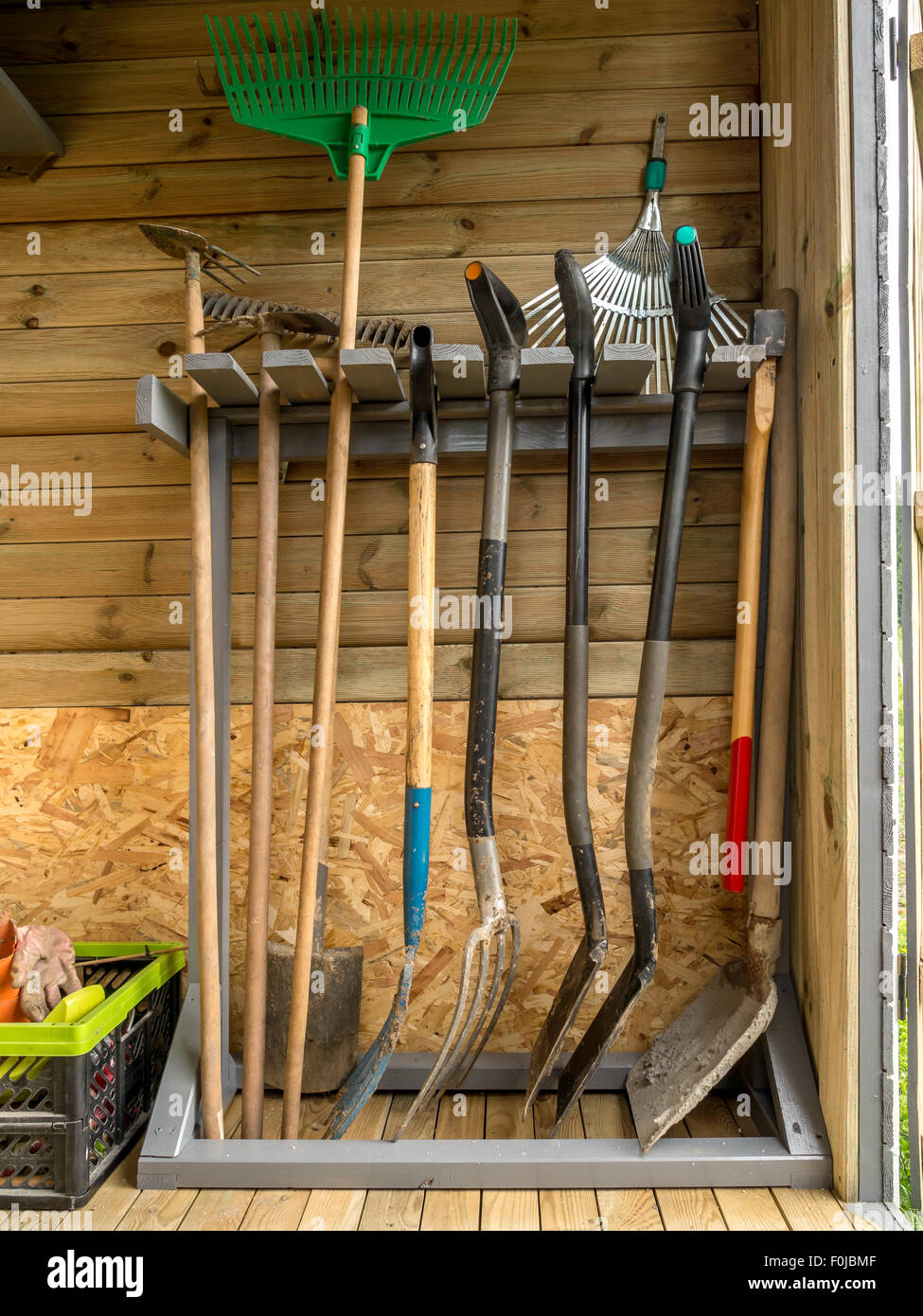 Wooden rack with different garden tools and equipment Stock Photo
