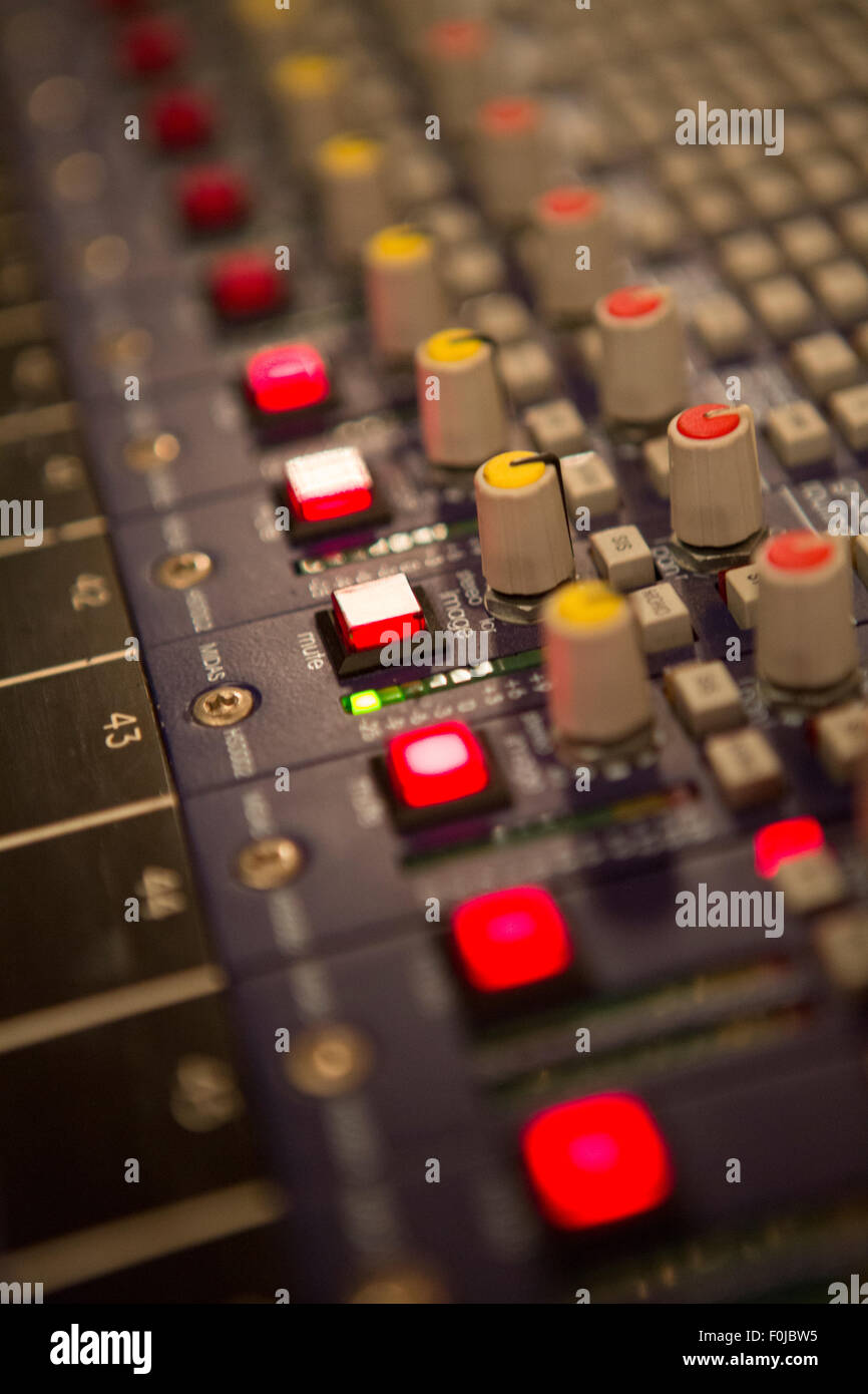 Audio mixer mixing board fader and knobs at night during a live concert