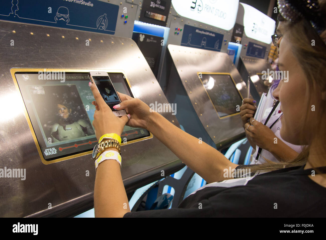 Anaheim, California, USA. 15th Aug, 2015. Melissa Hansen from Lakeville, MN takes a picture of the 3D Stormtrooper figure of herself she ordered at the Disney 3D Print Studio at the D23 Expo fan event at the Anaheim Convention Center in Anaheim, CA, USA August 16, 2015. Credit:  Kayte Deioma/Alamy Live News Stock Photo