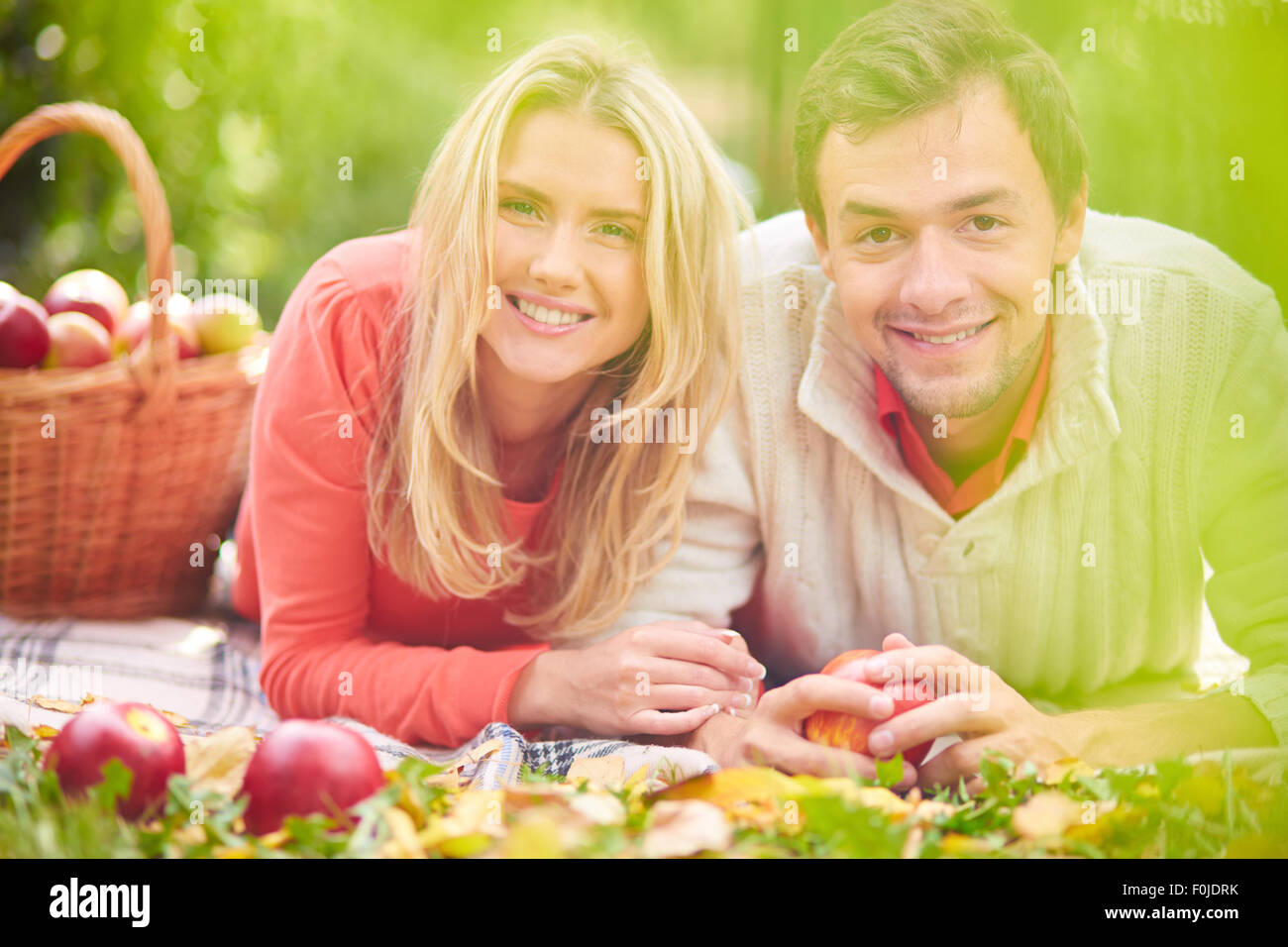 Happy young couple lying on grass in park Stock Photo - Alamy