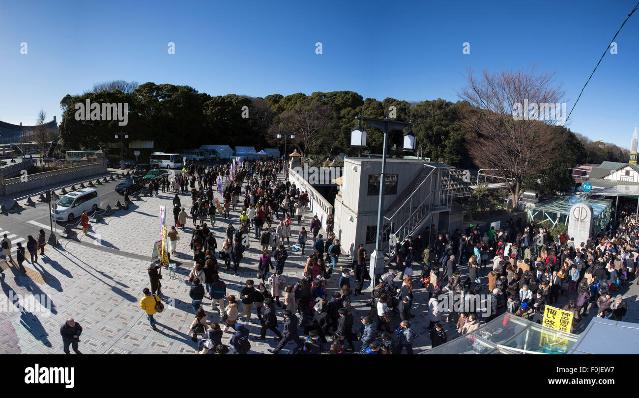 Large group of people walking out of Meiji shrine garden after a visit to the Meiji Jingu Shrine. It is very popular in Tokyo Stock Photo
