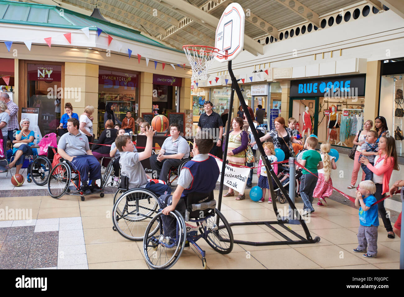 Disabled and able bodied children try out wheel chair basketball during a paralympic celebration in Aylesbury town centre. Stock Photo