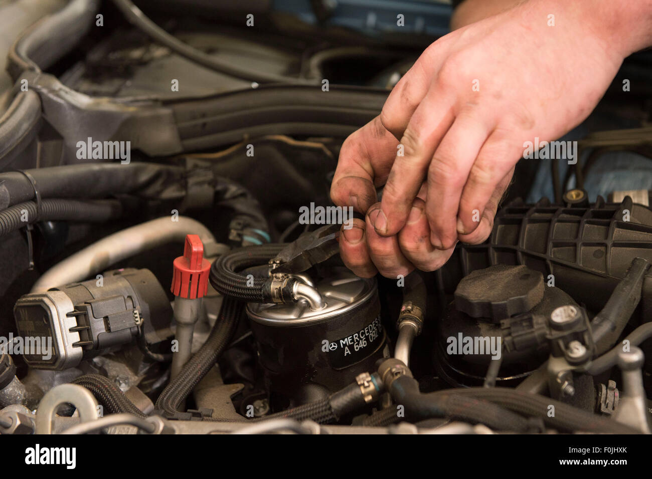 A car mechanic performing routine maintenance replacing an oil filter