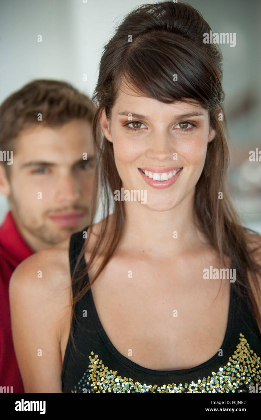 Young couple close together, male blurred behind the woman Stock Photo