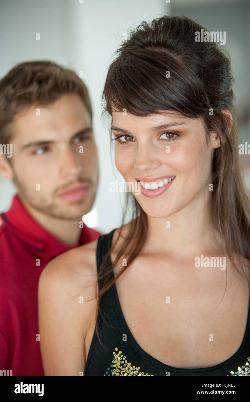 Young couple close together, male blurred behind the woman Stock Photo