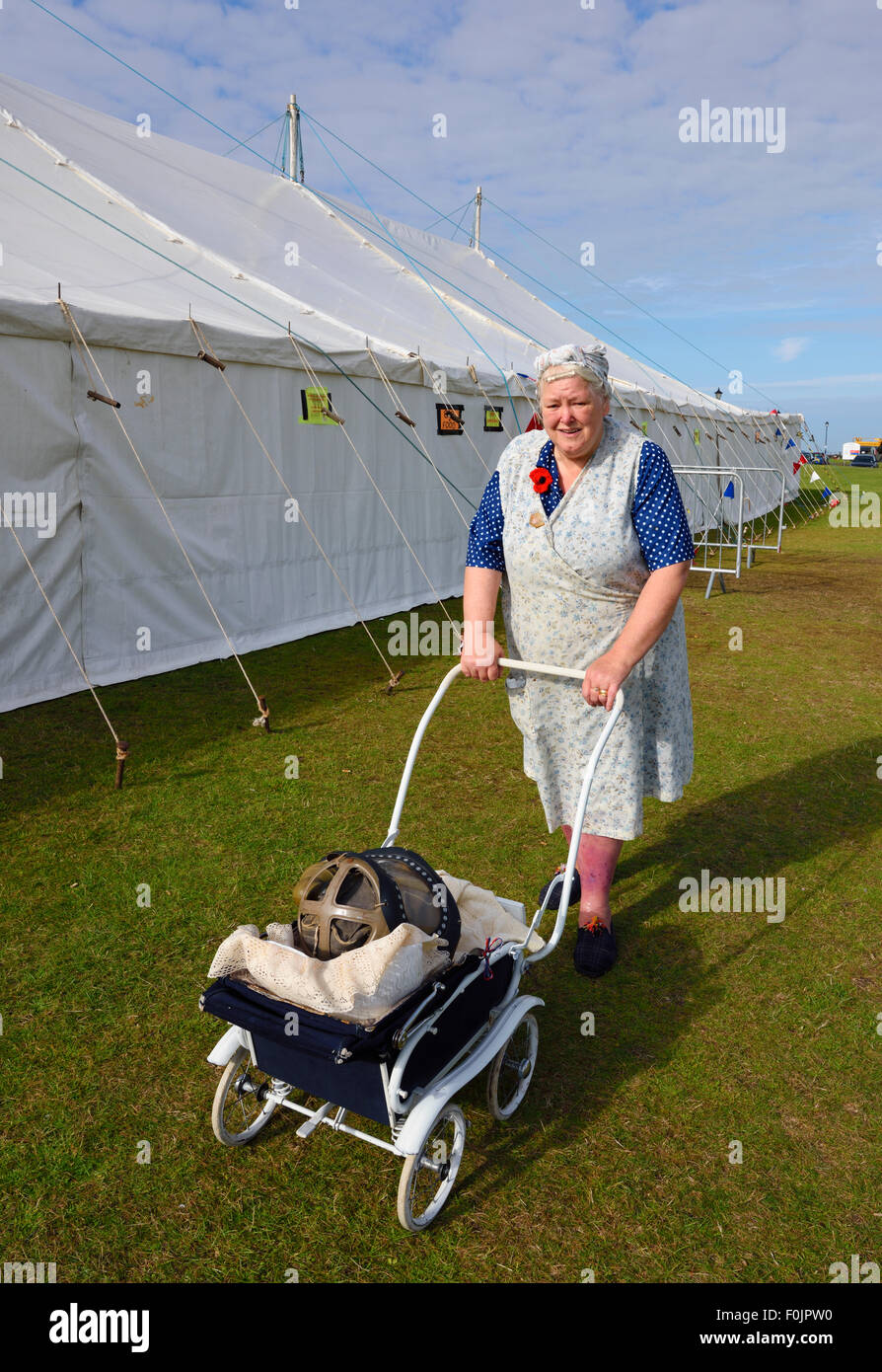 Lady in typical 1940s housewife dress, with pushchair Stock Photo
