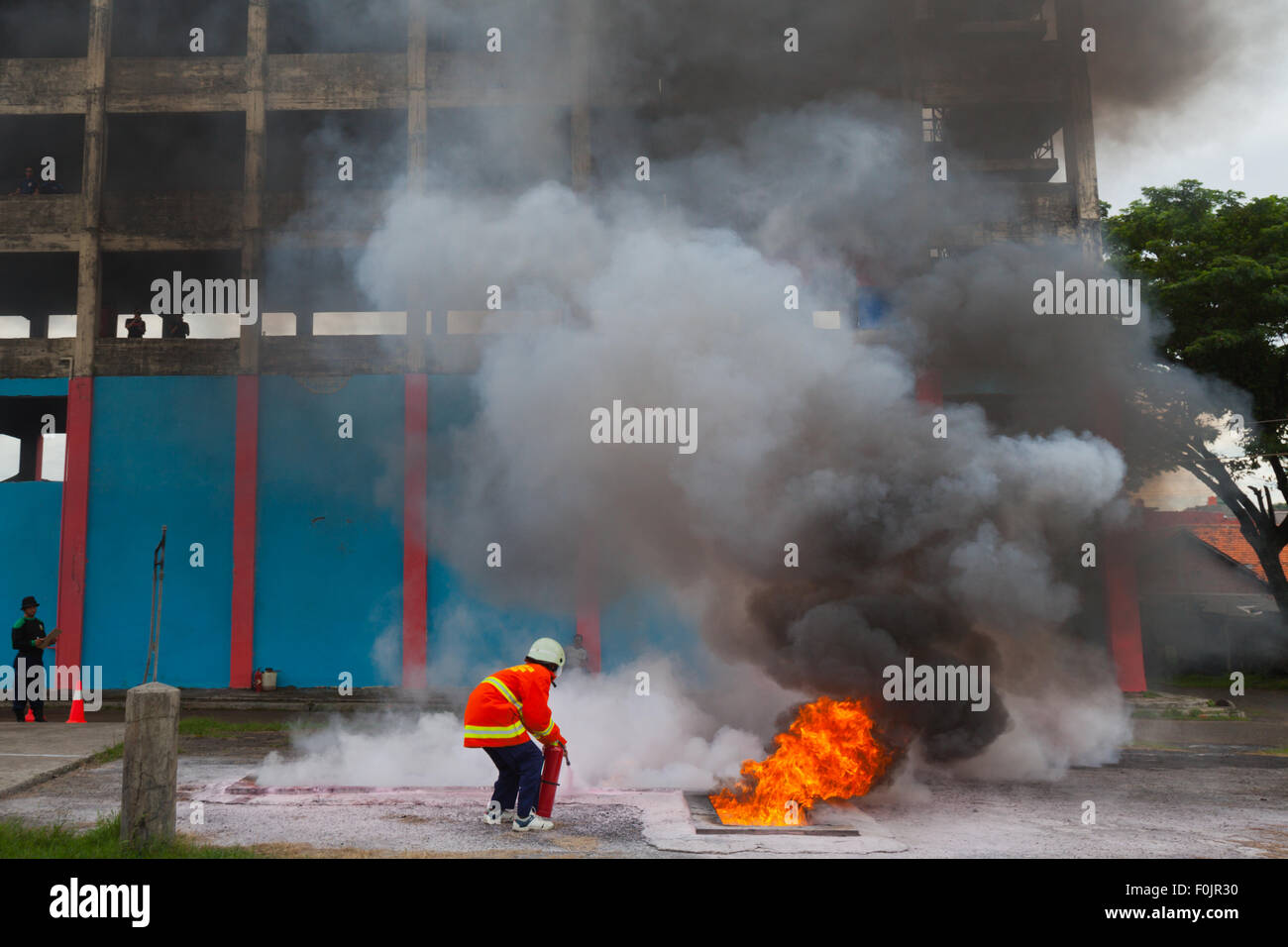 A contestant is performing a firefighting technique during a competition held between Jakarta fire brigade's firefighters in Jakarta, Indonesia. Stock Photo