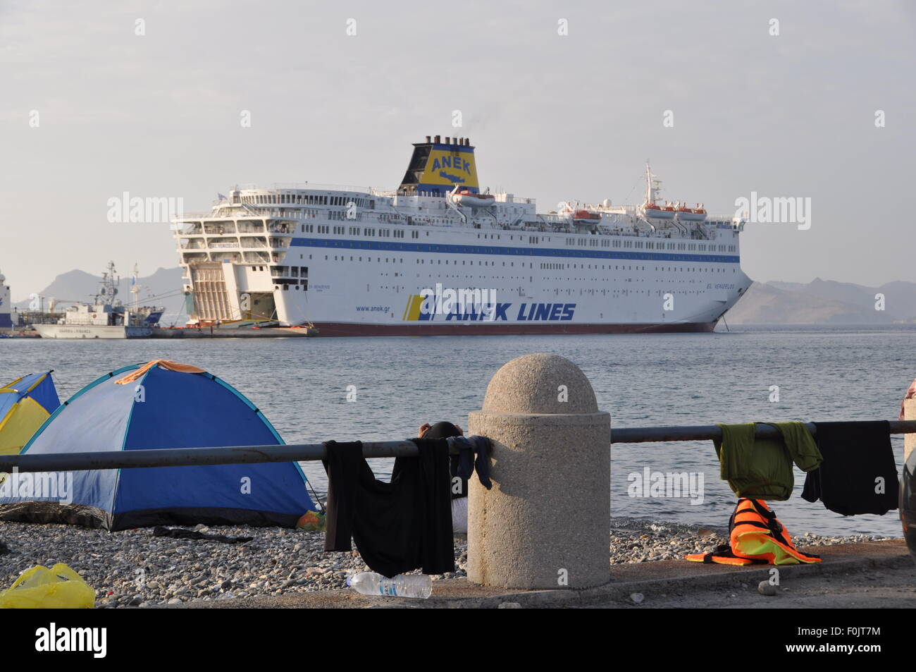 Kos, Greece. 15th Aug, 2015. Migrants and refugees wait at the port next to the ferry Eleftherios Venizelos after crossing from Turkey, at the southeastern island of Kos, Greece, Sturday, August 15, 2015. © Tereza Supova/CTK Photo/Alamy Live News Stock Photo