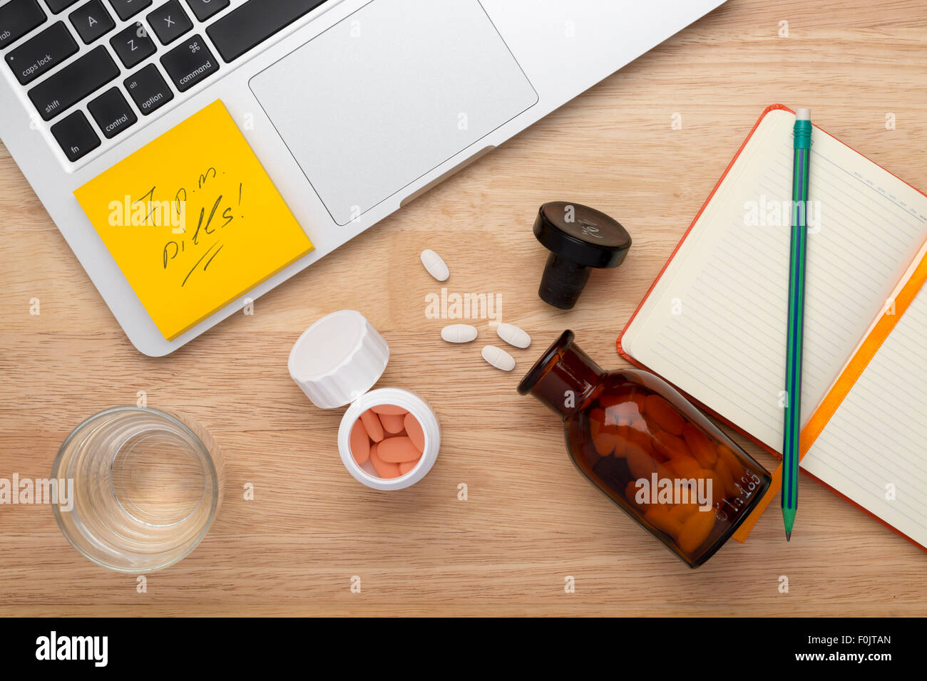 On-line treatment concept with bottles of medicine pills on the wooden table Stock Photo