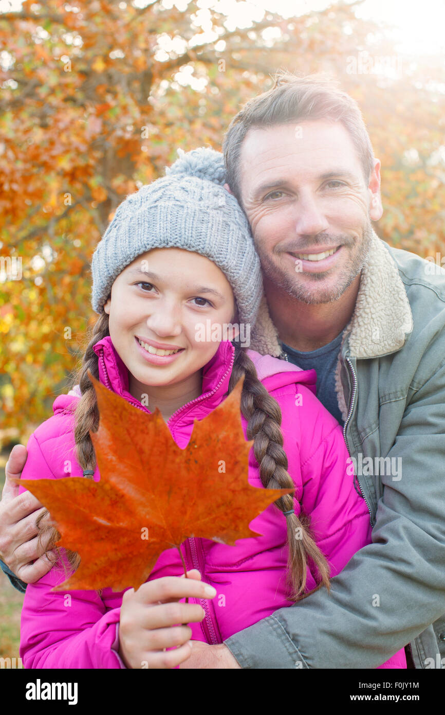 Portrait father and daughter with autumn leaf hugging Stock Photo