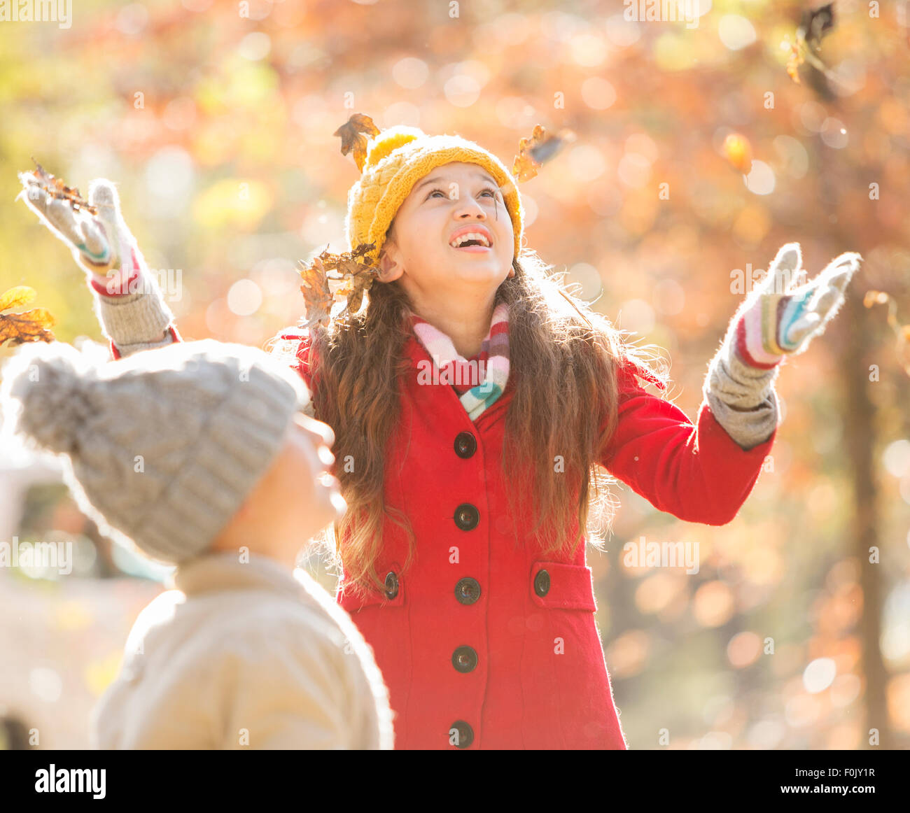 Girl throwing autumn leaves Stock Photo