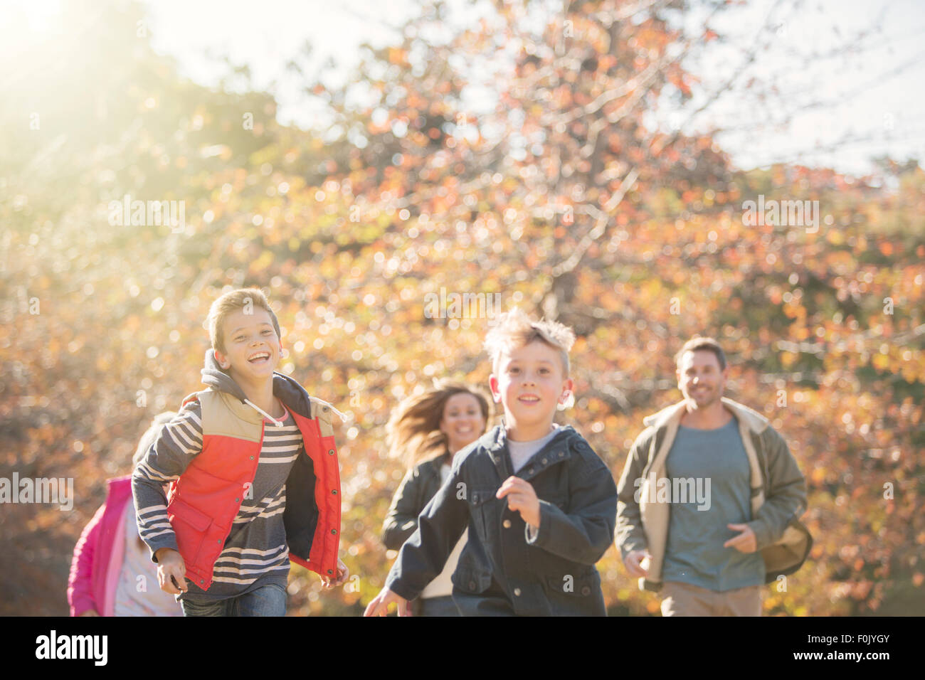 Energetic family running in autumn park Stock Photo